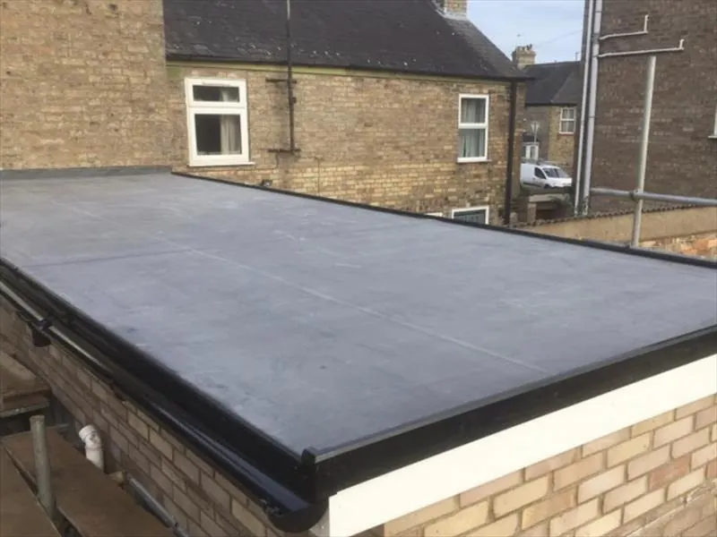 Dark flat roof on a rear extension of a yellow brick terraced house