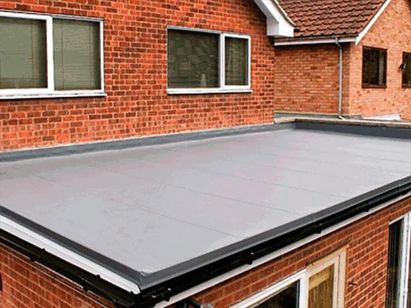 Grey GRP flat roof with a neat edge trim on a red brick extension